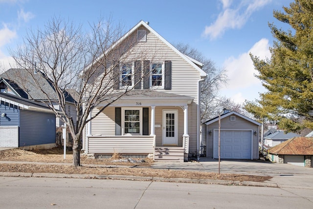 view of front facade with driveway, a porch, a detached garage, and an outdoor structure