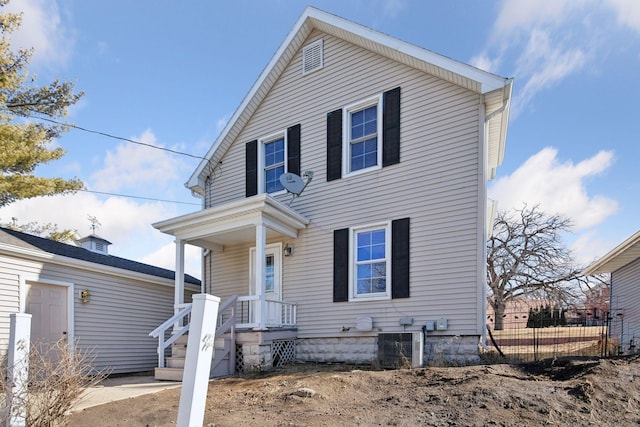 traditional-style house with central AC and fence