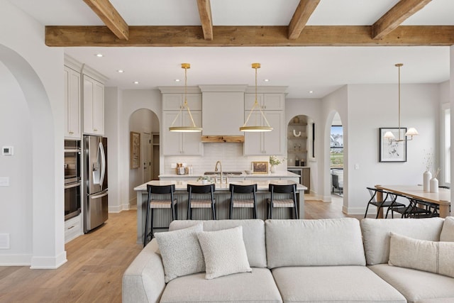5455 Rolling Hills Pkwy, Victoria, MN 55318 - living room with arched walkways, recessed lighting, light wood-style floors, beam ceiling, and baseboards