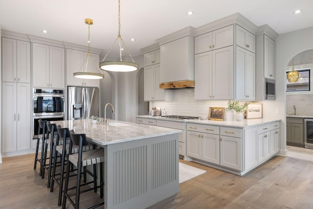 5455 Rolling Hills Pkwy, Victoria, MN 55318 - kitchen featuring appliances with stainless steel finishes, a sink, backsplash, a kitchen breakfast bar, and beverage cooler