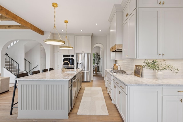 5455 Rolling Hills Pkwy, Victoria, MN 55318 - kitchen with arched walkways, stainless steel appliances, a kitchen bar, decorative backsplash, and recessed lighting