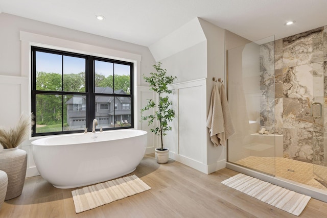 5455 Rolling Hills Pkwy, Victoria, MN 55318 - full bathroom featuring wood finished floors, a stall shower, a decorative wall, a soaking tub, and a wainscoted wall