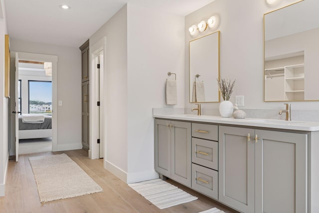 5455 Rolling Hills Pkwy, Victoria, MN 55318 - ensuite bathroom featuring double vanity, wood finished floors, baseboards, and recessed lighting