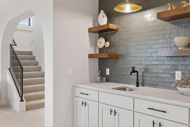 5455 Rolling Hills Pkwy, Victoria, MN 55318 - bar with a sink, backsplash, stairs, arched walkways, and baseboards