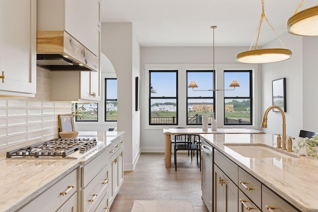 5455 Rolling Hills Pkwy, Victoria, MN 55318 - kitchen with stainless steel appliances, decorative backsplash, light stone countertops, light wood-style flooring, and custom range hood