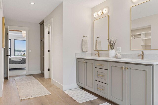 5455 Rolling Hills Pkwy, Victoria, MN 55318 - bathroom featuring double vanity, connected bathroom, wood finished floors, and recessed lighting