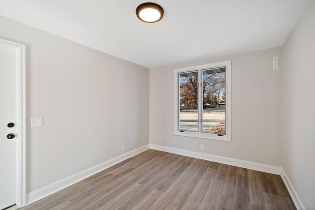 empty room featuring baseboards and wood finished floors