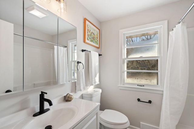 bathroom featuring toilet, vanity, and visible vents