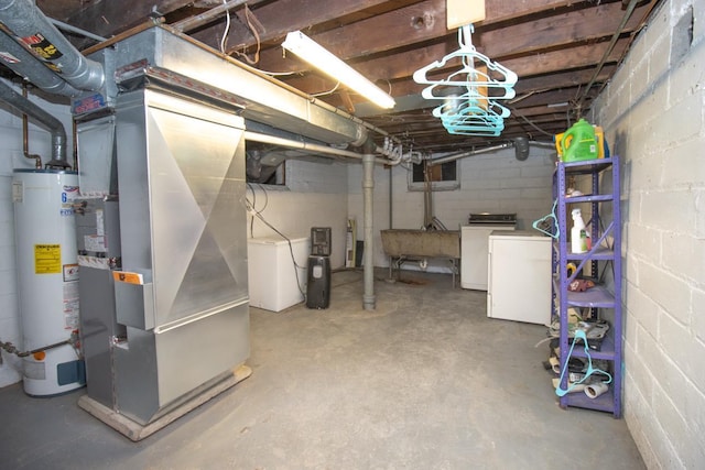 basement featuring heating unit, water heater, washer and dryer, and sink