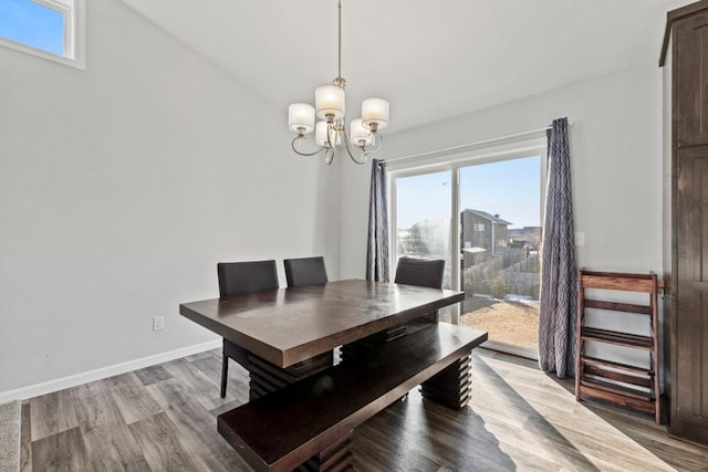 dining space featuring a notable chandelier, a wealth of natural light, and hardwood / wood-style flooring