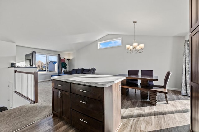 kitchen featuring plenty of natural light, a chandelier, hanging light fixtures, and lofted ceiling