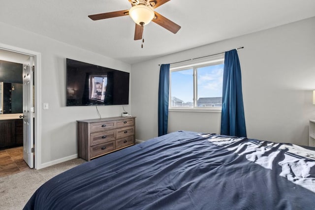 bedroom with ceiling fan, light carpet, and connected bathroom