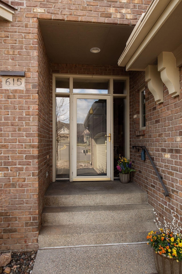view of exterior entry featuring brick siding