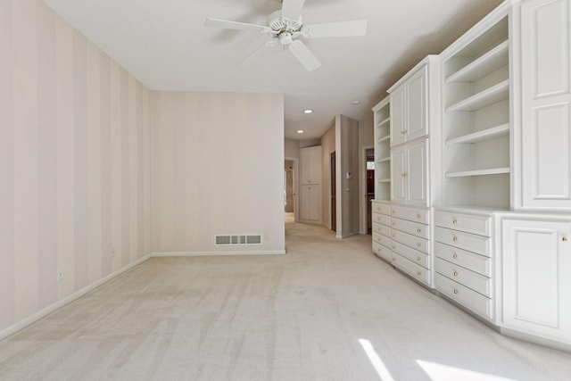 unfurnished living room featuring visible vents, baseboards, a ceiling fan, and light colored carpet