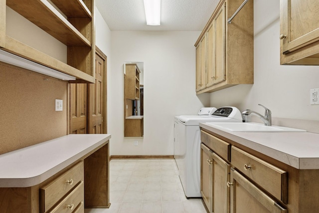 clothes washing area featuring baseboards, a sink, cabinet space, light floors, and washing machine and clothes dryer