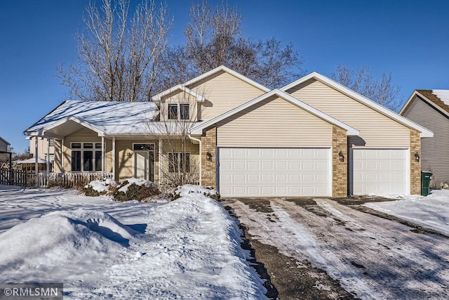 view of front of property featuring covered porch, driveway, brick siding, and an attached garage