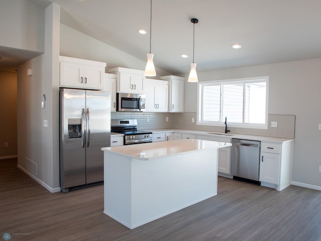 kitchen with white cabinets, appliances with stainless steel finishes, light countertops, and pendant lighting