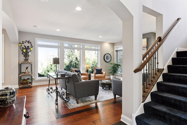 221 George St, Excelsior, MN 55331 - living area with arched walkways, dark wood-type flooring, stairs, baseboards, and recessed lighting