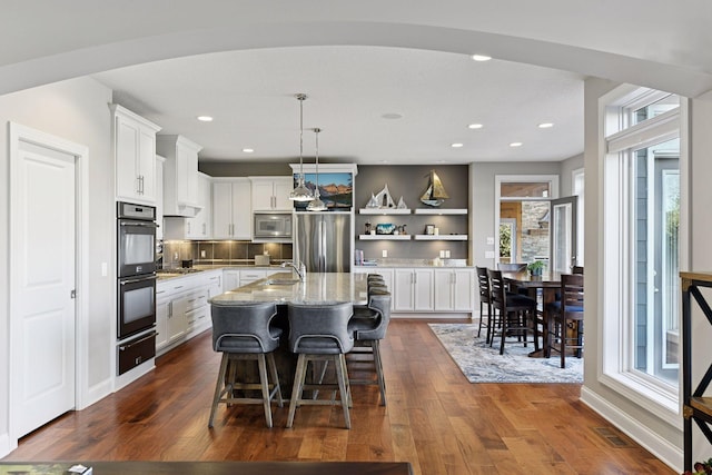 221 George St, Excelsior, MN 55331 - kitchen with stainless steel appliances, a warming drawer, open shelves, white cabinetry, and healthy amount of natural light