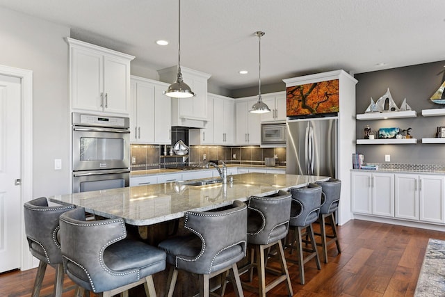 221 George St, Excelsior, MN 55331 - kitchen with appliances with stainless steel finishes, dark wood-type flooring, a sink, recessed lighting, and white cabinets