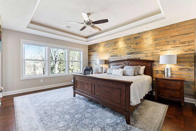 221 George St, Excelsior, MN 55331 - bedroom with a tray ceiling, dark wood-style flooring, baseboards, wood walls, and a ceiling fan