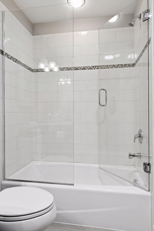 221 George St, Excelsior, MN 55331 - full bath featuring toilet, bath / shower combo with glass door, a textured ceiling, and tile patterned floors