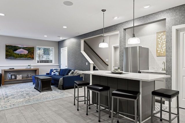 221 George St, Excelsior, MN 55331 - kitchen with freestanding refrigerator, a breakfast bar, a center island, a sink, and pendant lighting