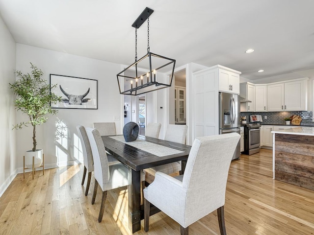 dining area featuring recessed lighting, baseboards, light wood finished floors, and an inviting chandelier