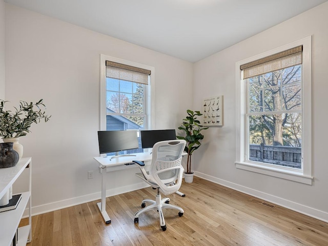 office space with light wood finished floors, baseboards, and visible vents