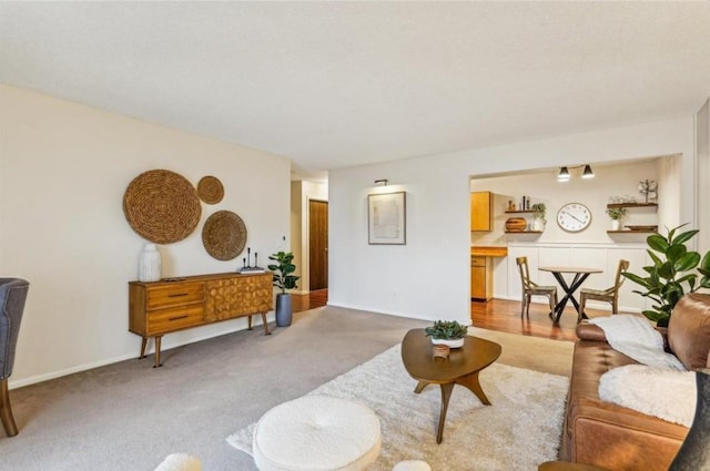 living room with baseboards and light colored carpet