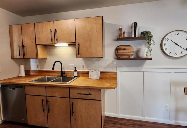 kitchen featuring brown cabinetry, a sink, backsplash, and stainless steel dishwasher