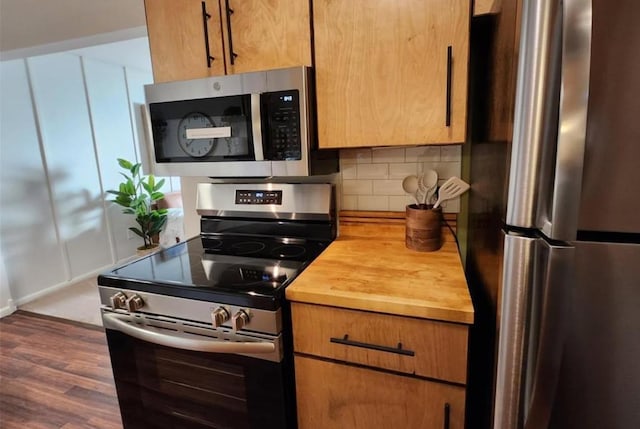 kitchen with dark wood-style floors, brown cabinets, backsplash, appliances with stainless steel finishes, and butcher block countertops