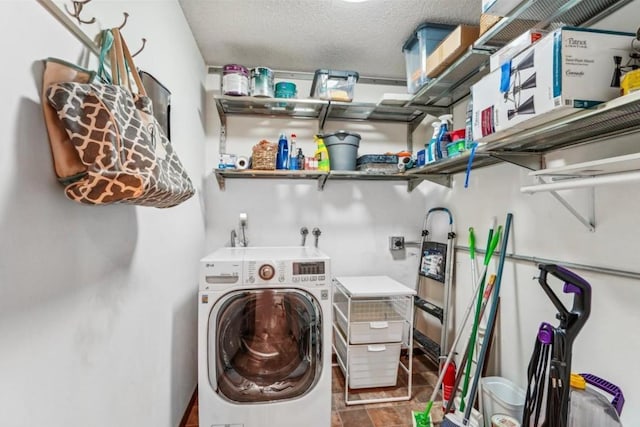 washroom with washer / clothes dryer, a textured ceiling, and laundry area