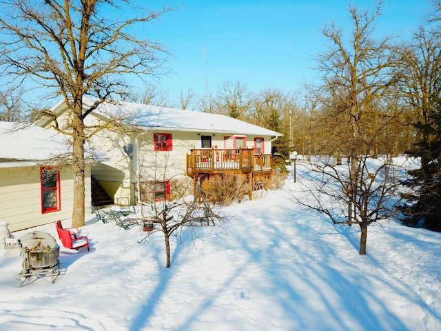 snow covered house featuring a wooden deck