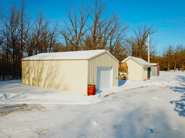 snow covered garage featuring a detached garage