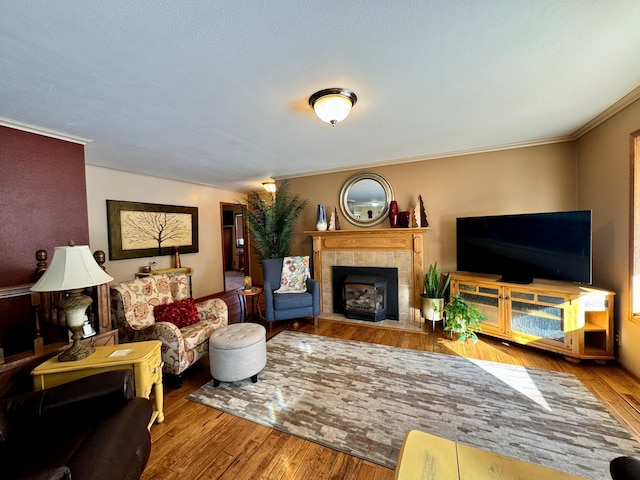 living room with ornamental molding, a fireplace, and wood finished floors