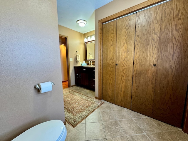 bathroom featuring toilet, vanity, and tile patterned floors