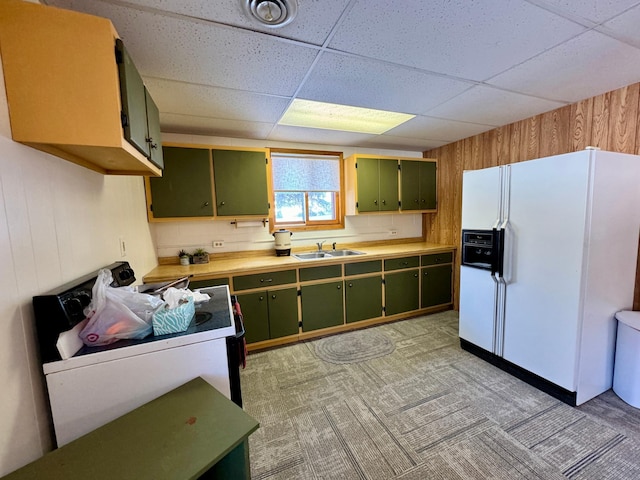 kitchen featuring white refrigerator with ice dispenser, light countertops, and green cabinets