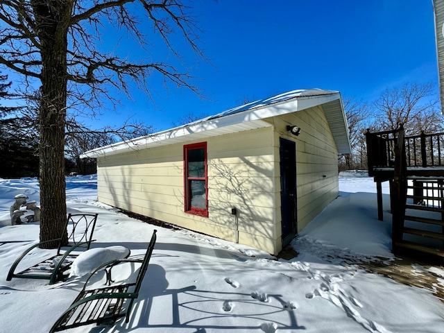 snow covered property featuring an outbuilding