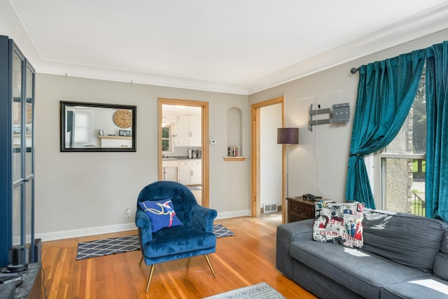 living room featuring wood finished floors, visible vents, and baseboards