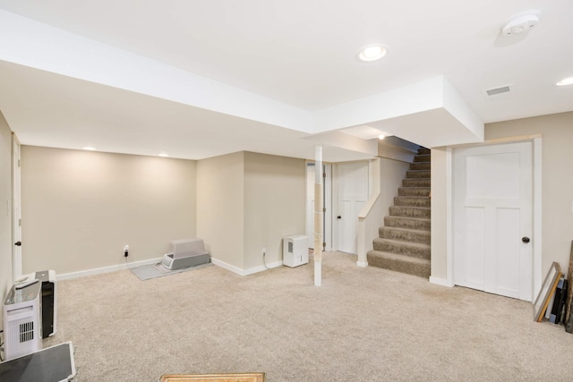 finished below grade area featuring stairs, recessed lighting, baseboards, and light colored carpet