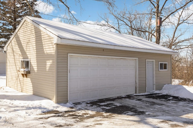 snow covered garage featuring a garage