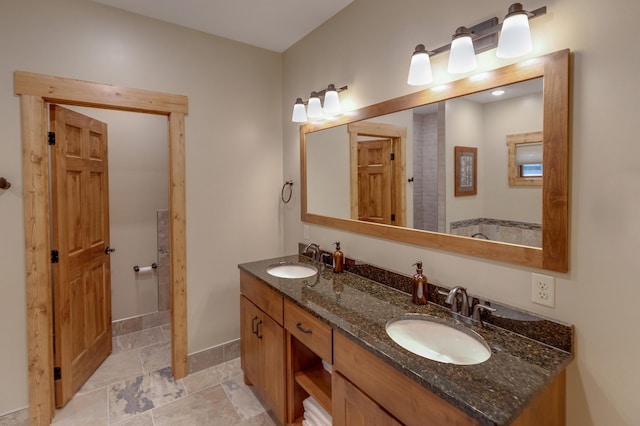 bathroom with double vanity, baseboards, and a sink