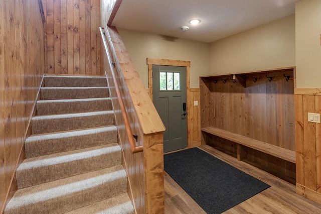 mudroom with wood finished floors and wooden walls