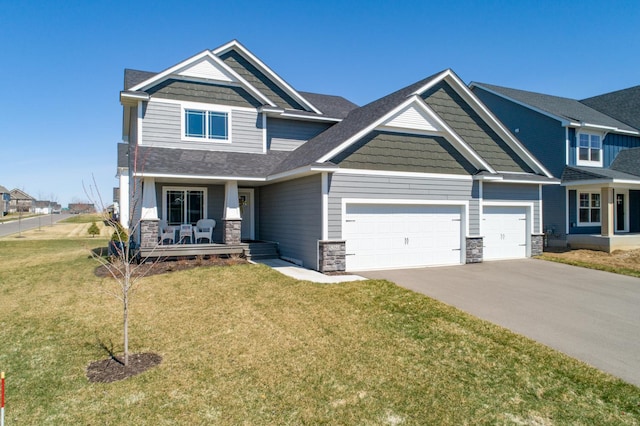 craftsman-style home featuring a porch, an attached garage, concrete driveway, stone siding, and a front lawn