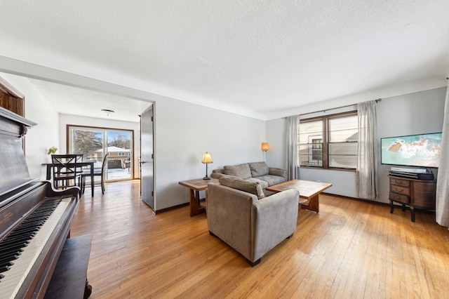 living room featuring a wealth of natural light, light wood-style flooring, and a textured ceiling