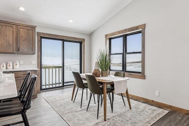 dining space with lofted ceiling and light hardwood / wood-style floors