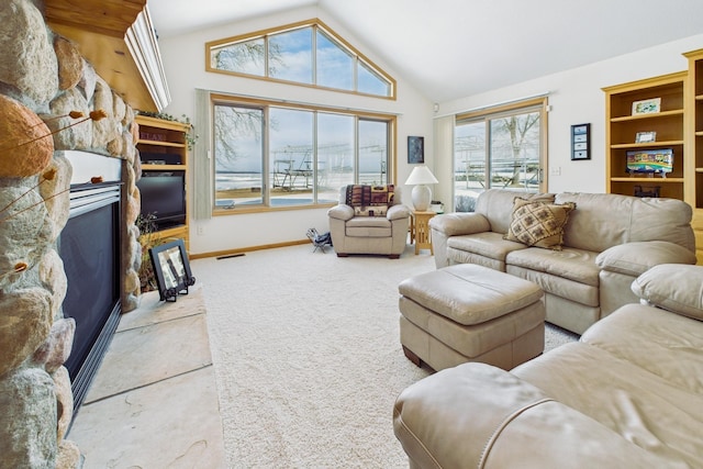 living room with baseboards, visible vents, carpet flooring, a stone fireplace, and high vaulted ceiling