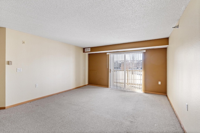 carpeted spare room with a textured ceiling