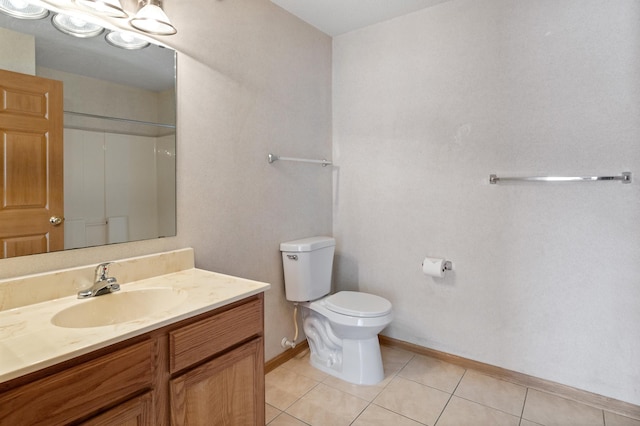 bathroom featuring vanity, tile patterned flooring, toilet, and walk in shower